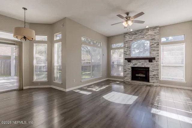 a view of a room with wooden floor fireplace and window