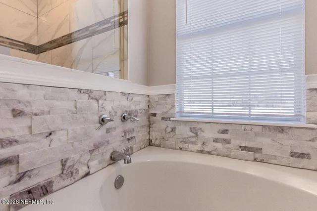 a bathroom with a bathtub and a window