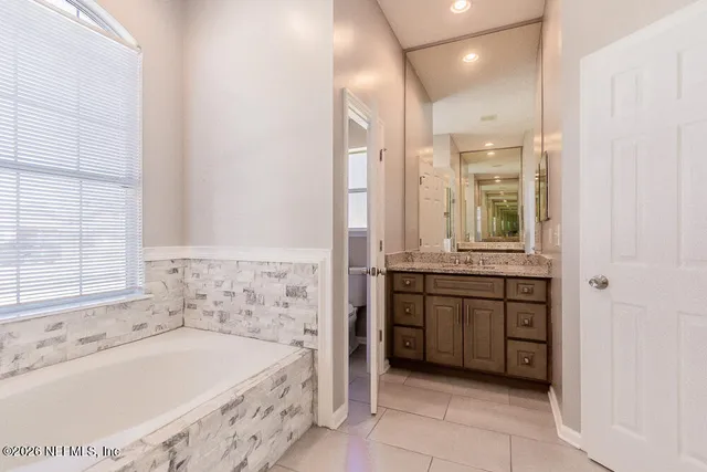 a bathroom with a bathtub sink and window