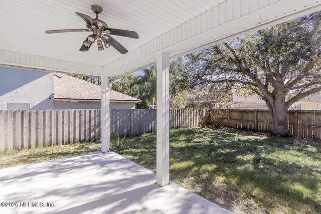 a view of a porch in front of a house with a large tree