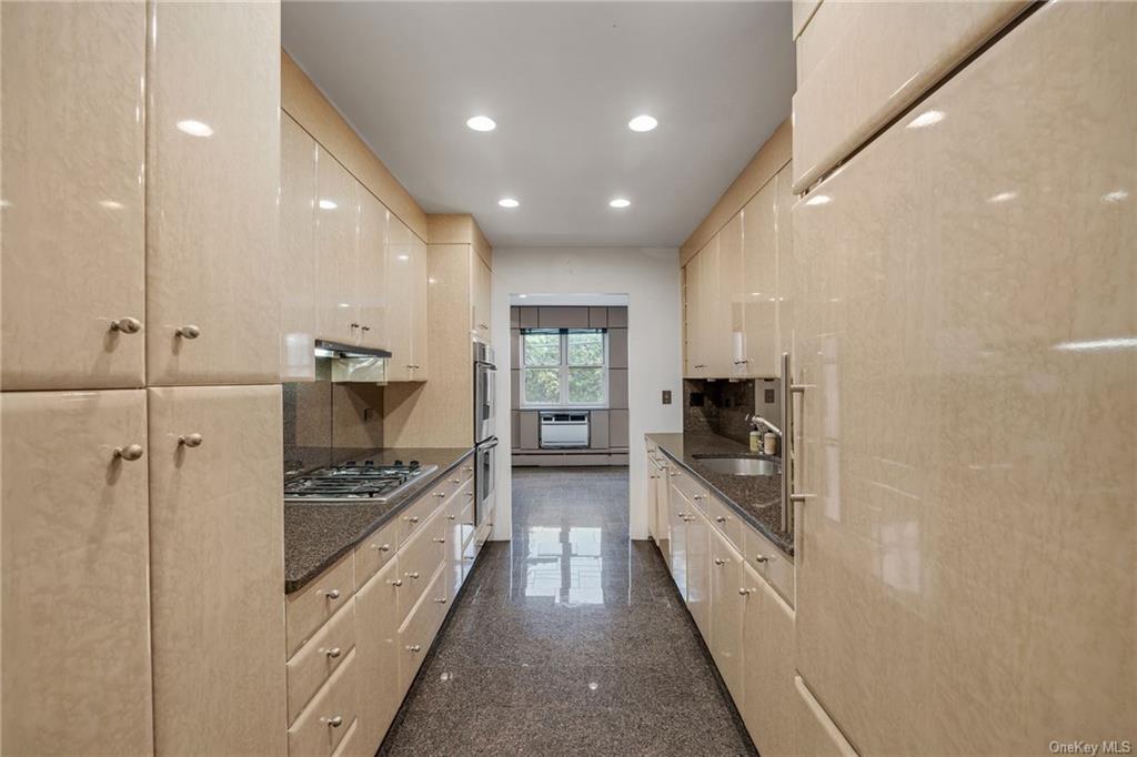 a kitchen with stainless steel appliances kitchen island granite countertop a stove and a refrigerator