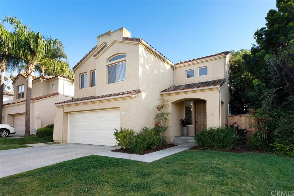 a front view of a house with a garden and plants