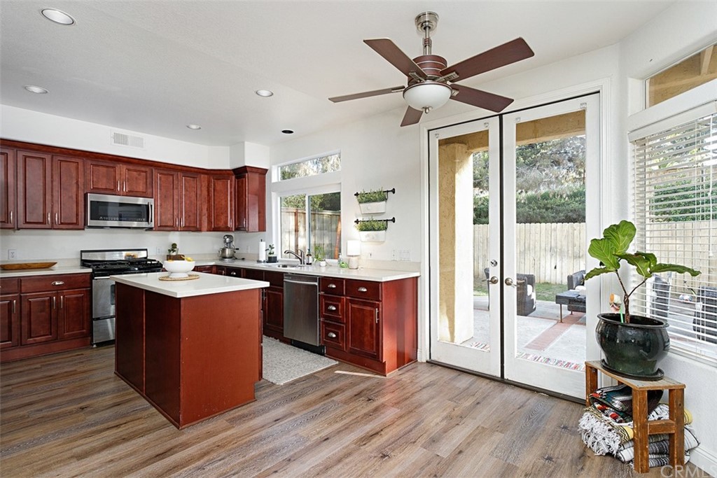 3660 Via Bernardo Oceanside, CA 92056 - Photo 6 of 34 a kitchen with stainless steel appliances granite countertop wooden floors a stove and a refrigerator