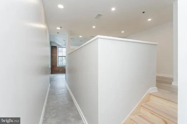 a view of a hallway with wooden floor