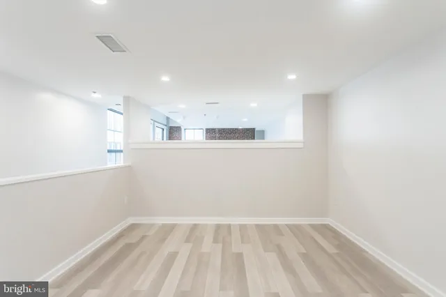 wooden floor in an empty room with a kitchen