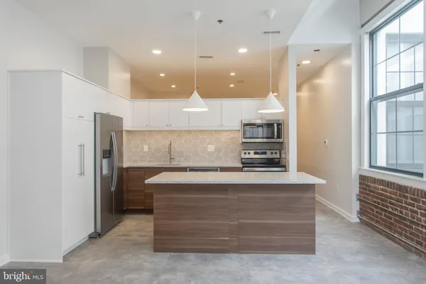 a view of kitchen with center island and stainless steel appliances