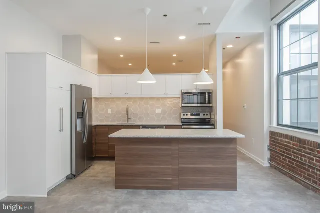 a view of kitchen with center island and stainless steel appliances