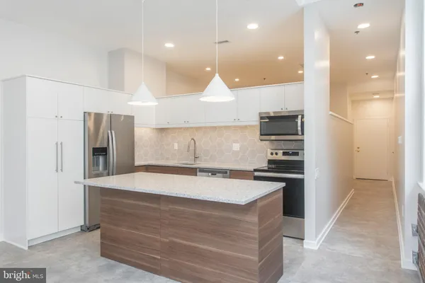a kitchen with kitchen island a sink stainless steel appliances and cabinets