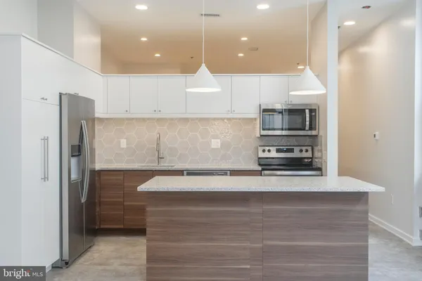 a kitchen with stainless steel appliances a refrigerator sink and microwave