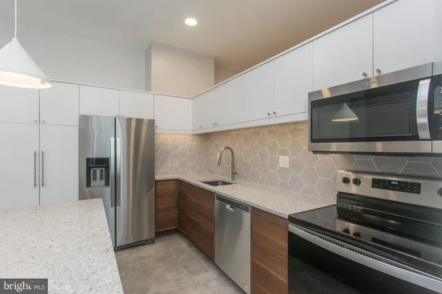a kitchen with stainless steel appliances a refrigerator a stove and a sink