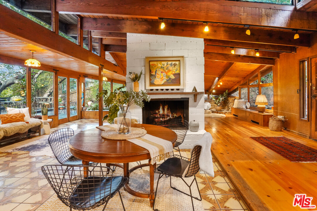 20881 Waveview Drive Topanga, CA 90290 - Photo 15 of 54 a dining room with furniture a fireplace and a chandelier