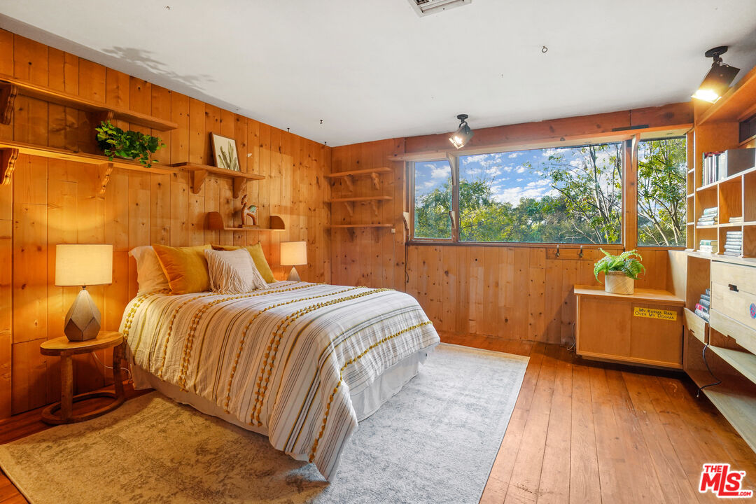 20881 Waveview Drive Topanga, CA 90290 - Photo 25 of 54 a bedroom with a bed and wooden floor