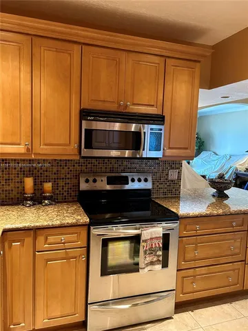 a kitchen with granite countertop cabinets stainless steel appliances and wooden cabinets
