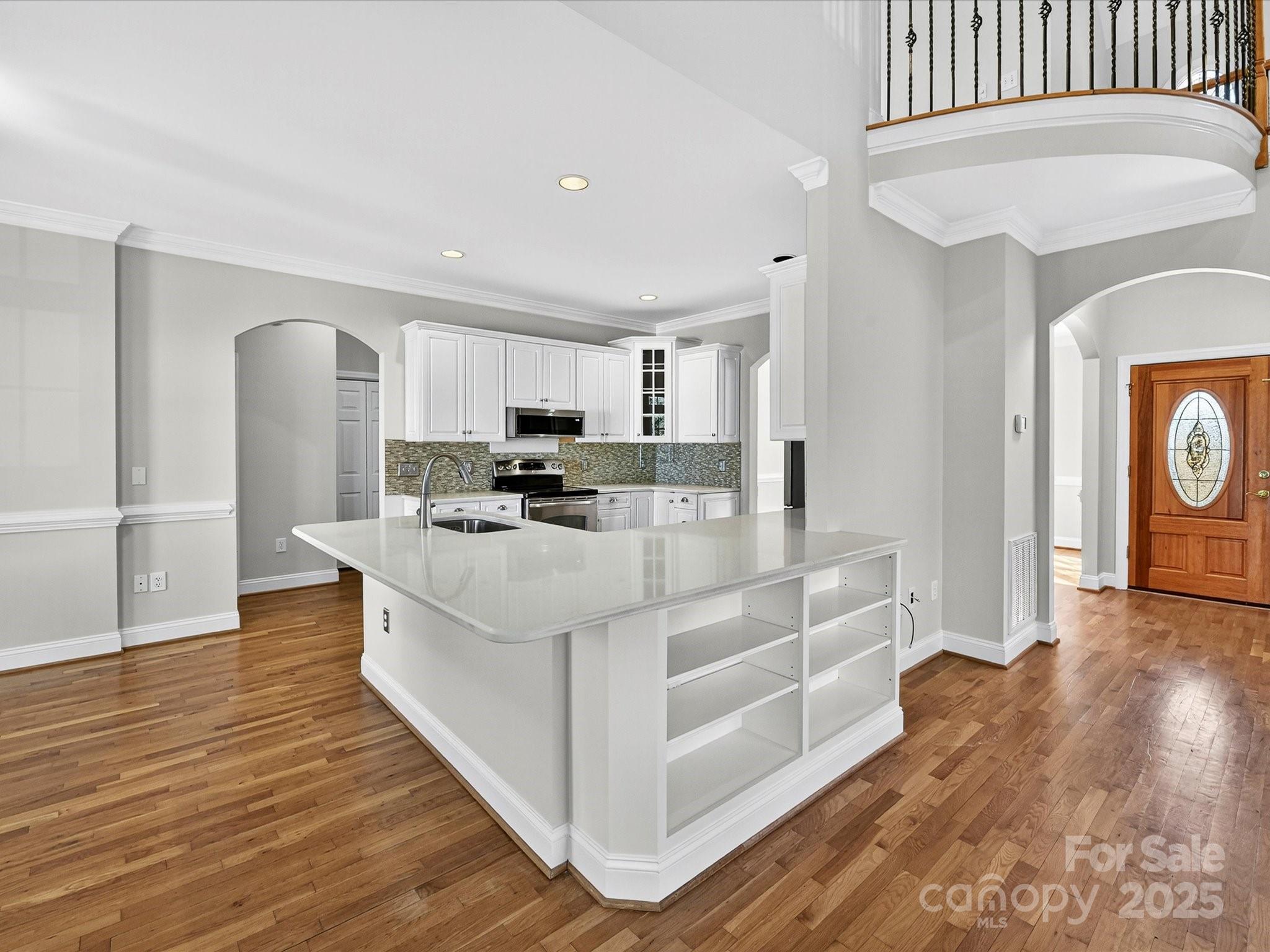 21410 Pinecrest Place Cornelius, NC 28031 - Photo 11 of 43 a large white kitchen with wooden floors and stainless steel appliances
