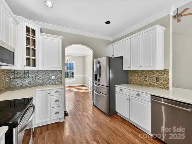 a kitchen with white cabinets and stainless steel appliances