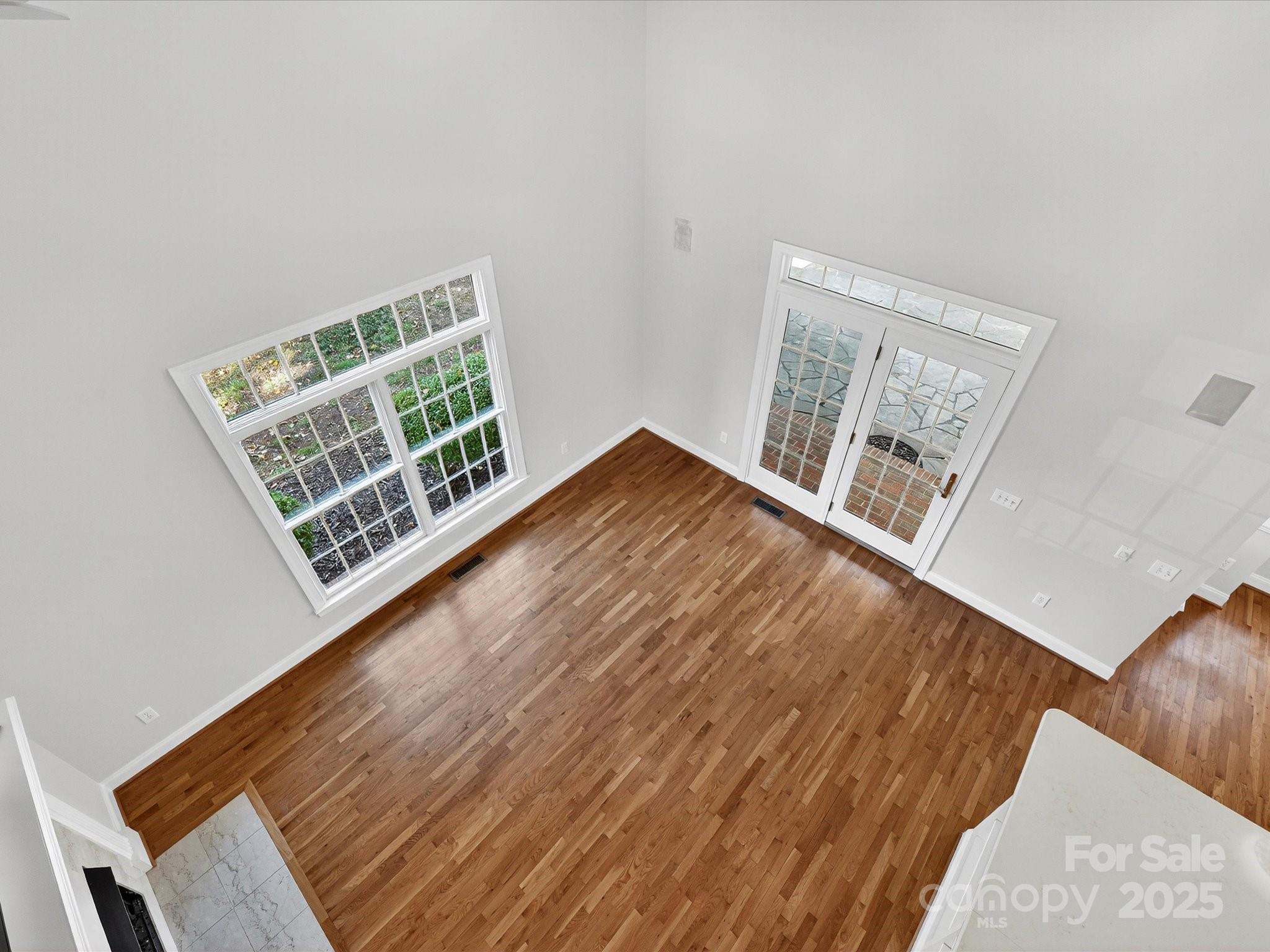 21410 Pinecrest Place Cornelius, NC 28031 - Photo 19 of 43 a view of an empty room with wooden floor and a window