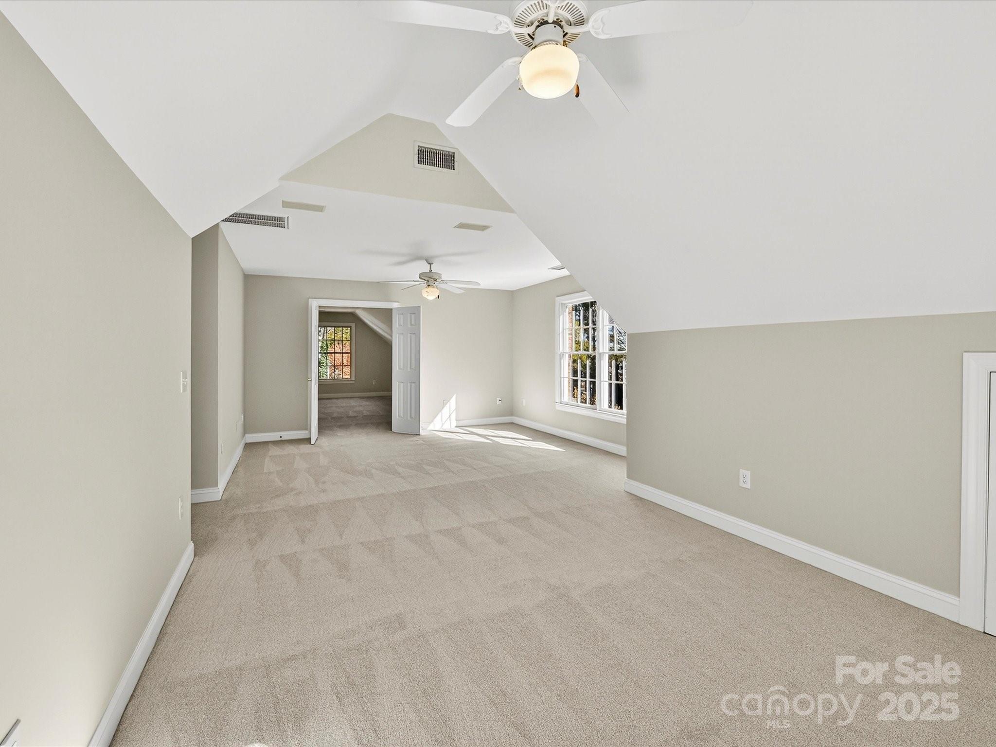 21410 Pinecrest Place Cornelius, NC 28031 - Photo 33 of 43 an empty room with a chandelier fan and windows