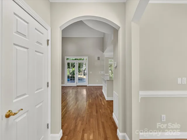 a view of a hallway with wooden floor and a living room