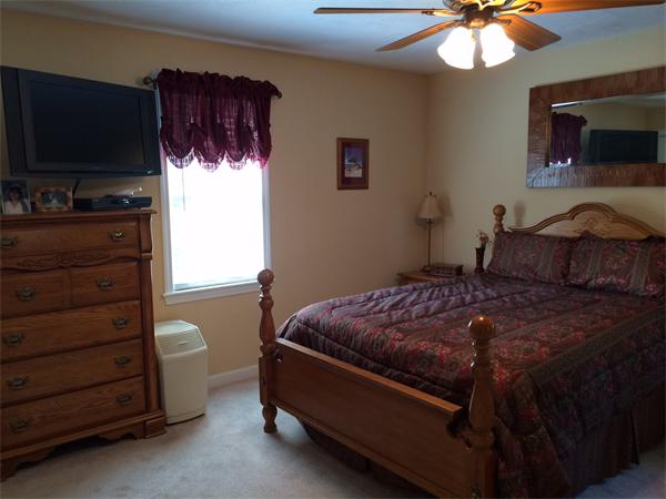 240 Pleasantdale Road Rutland, MA 01543 - Photo 12 of 25 a bedroom with a bed and a flat tv screen on dresser