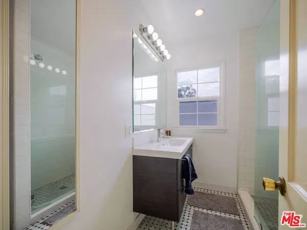 a bathroom with a sink mirror and a shower