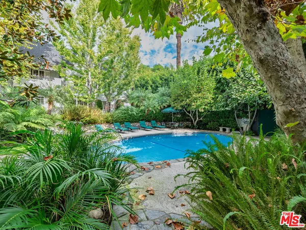 a view of a garden with large trees