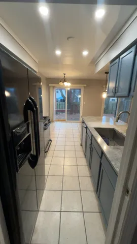 a kitchen with granite countertop a refrigerator and a sink