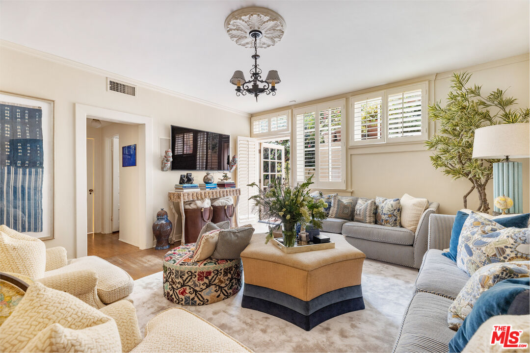 175 West Channel Road Santa Monica, CA 90402 - Photo 7 of 27 a living room with furniture a chandelier and a flat screen tv