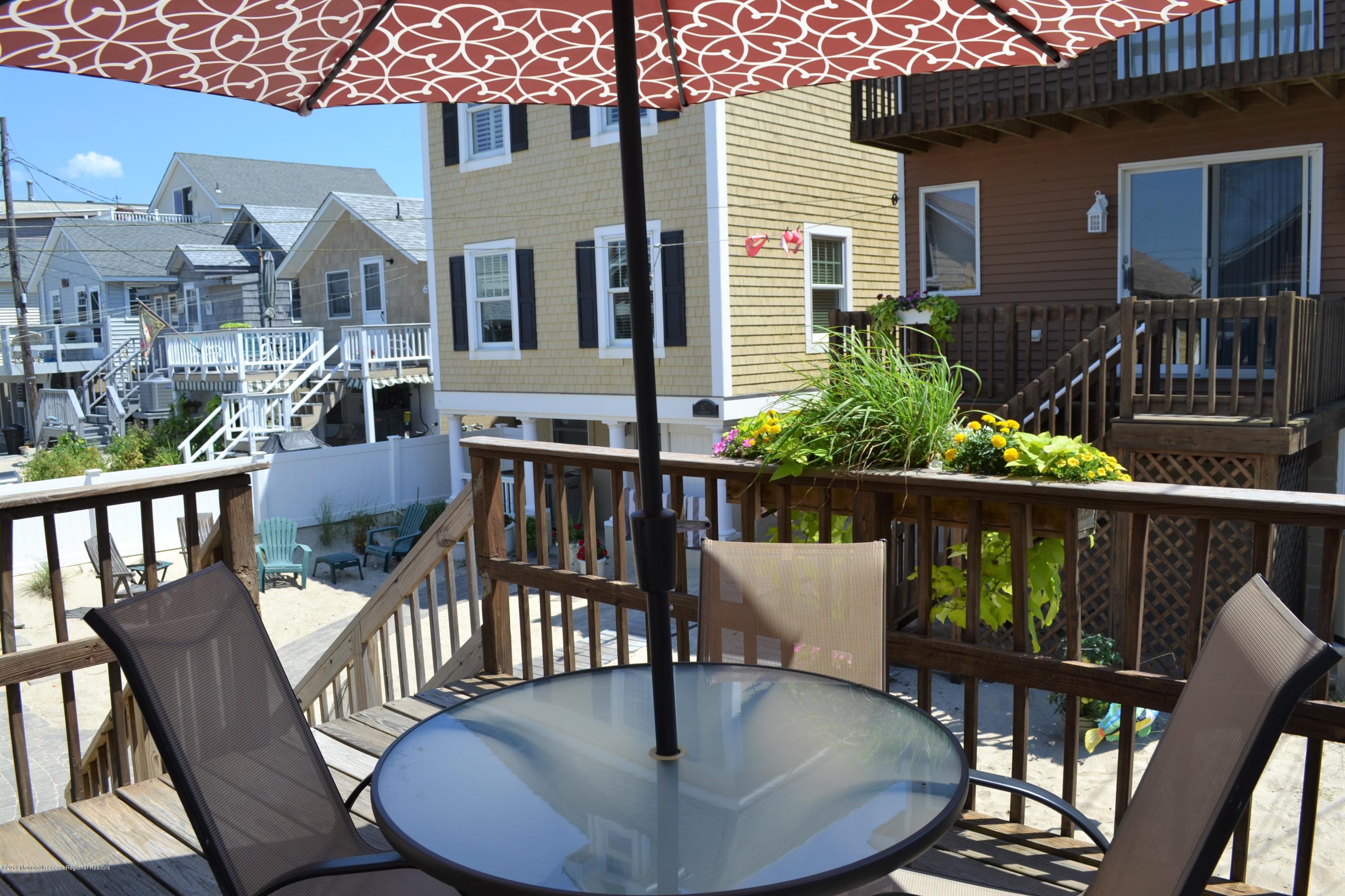 66 1st Avenue Manasquan, NJ 08736 - Photo 11 of 14 a balcony with wooden floor table and chairs
