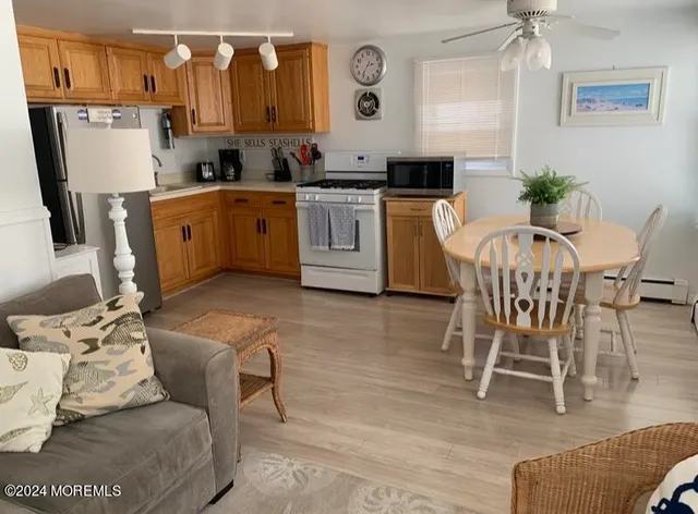 a kitchen with stainless steel appliances granite countertop a sink a stove a dining table and chairs