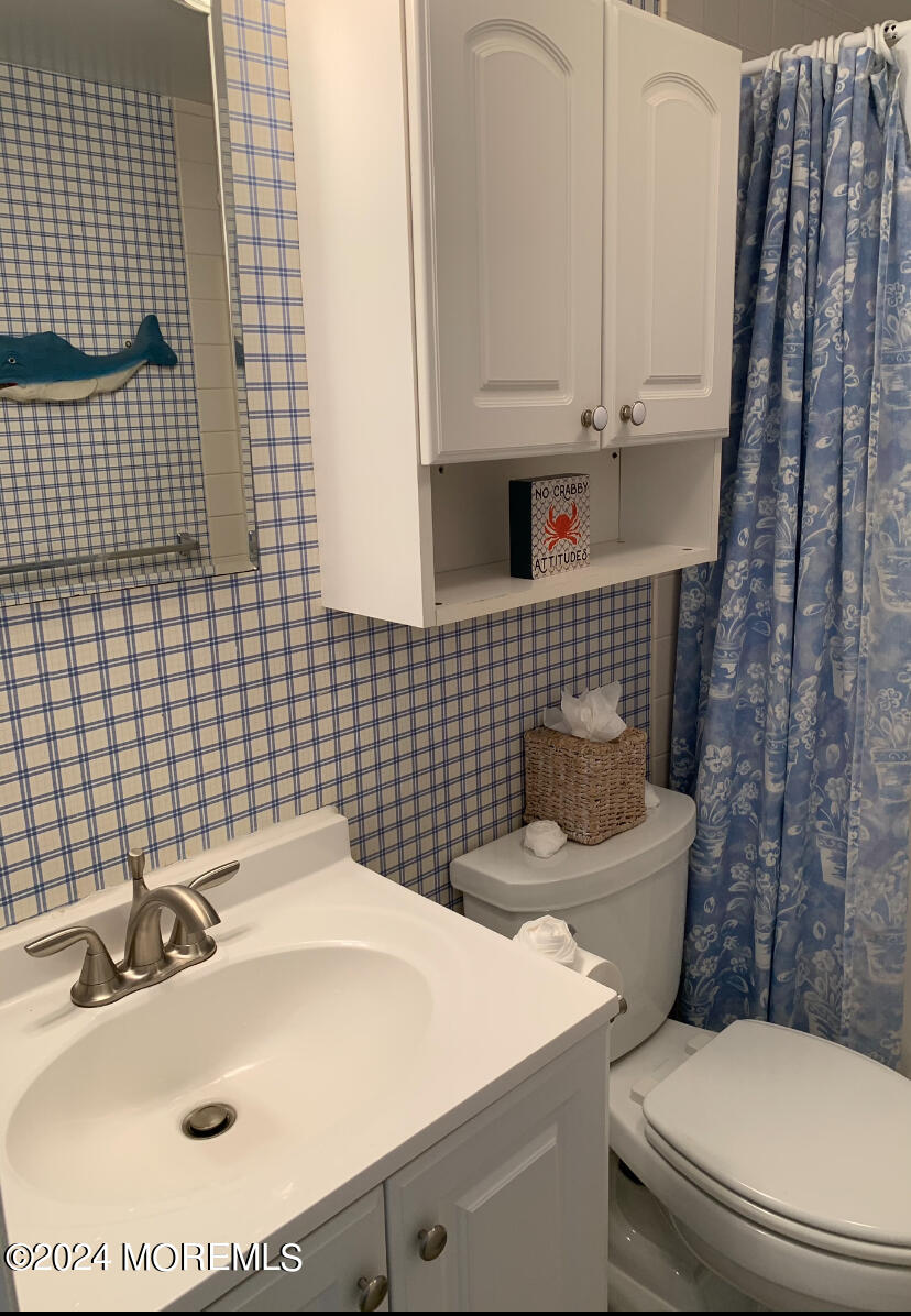 66 1st Avenue Manasquan, NJ 08736 - Photo 8 of 14 a bathroom with a sink a toilet and a mirror