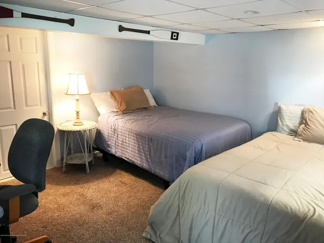 a bedroom with two beds and a chair