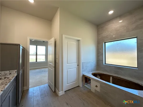 a kitchen with stainless steel appliances granite countertop a refrigerator a sink and wooden floor