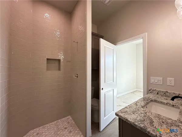 a bathroom with a granite countertop sink and a mirror