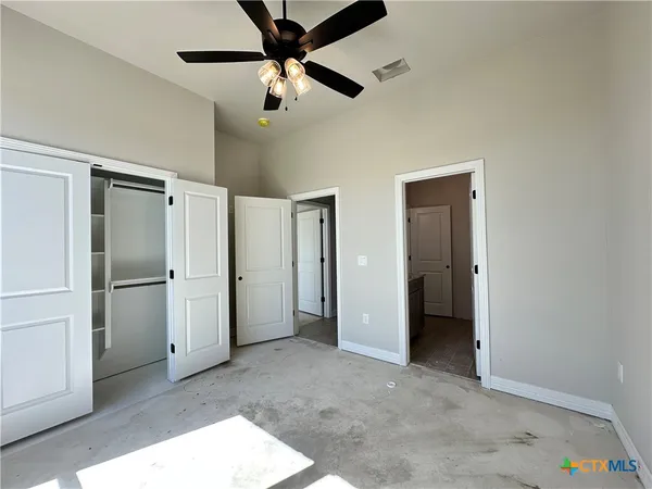 a view of an empty room with a ceiling fan