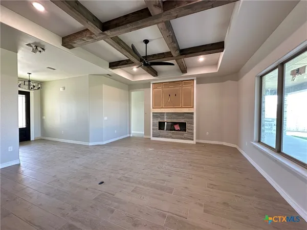 a view of empty room with a fireplace and windows