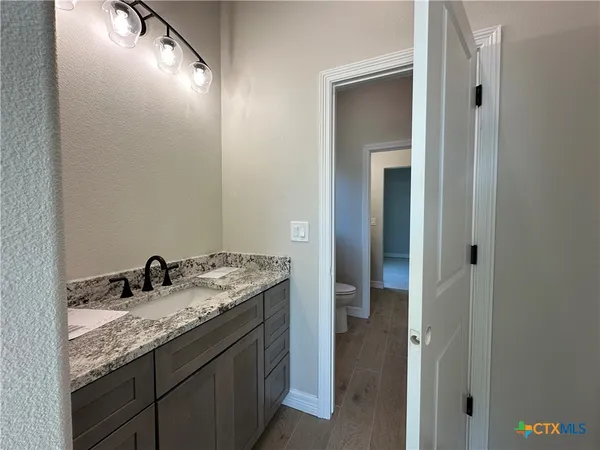 a bathroom with a granite countertop sink and a mirror