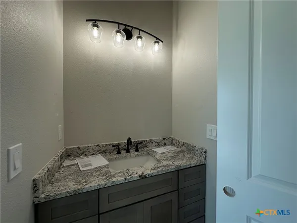 a bathroom with a granite countertop sink and vanity