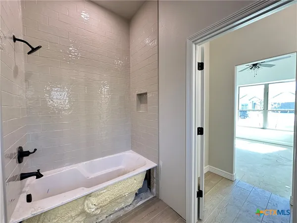 a bathroom with a tub shower and a sink