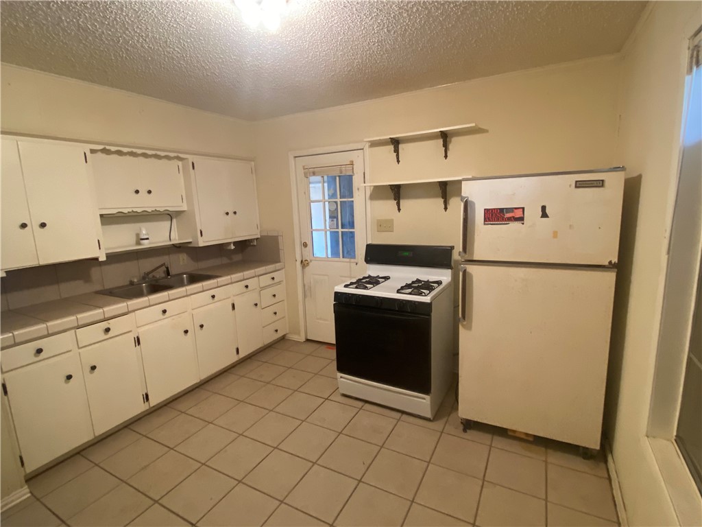 1015 Louis Street Alice, TX 78332 - Photo 11 of 20 a kitchen with stainless steel appliances a refrigerator sink and cabinets