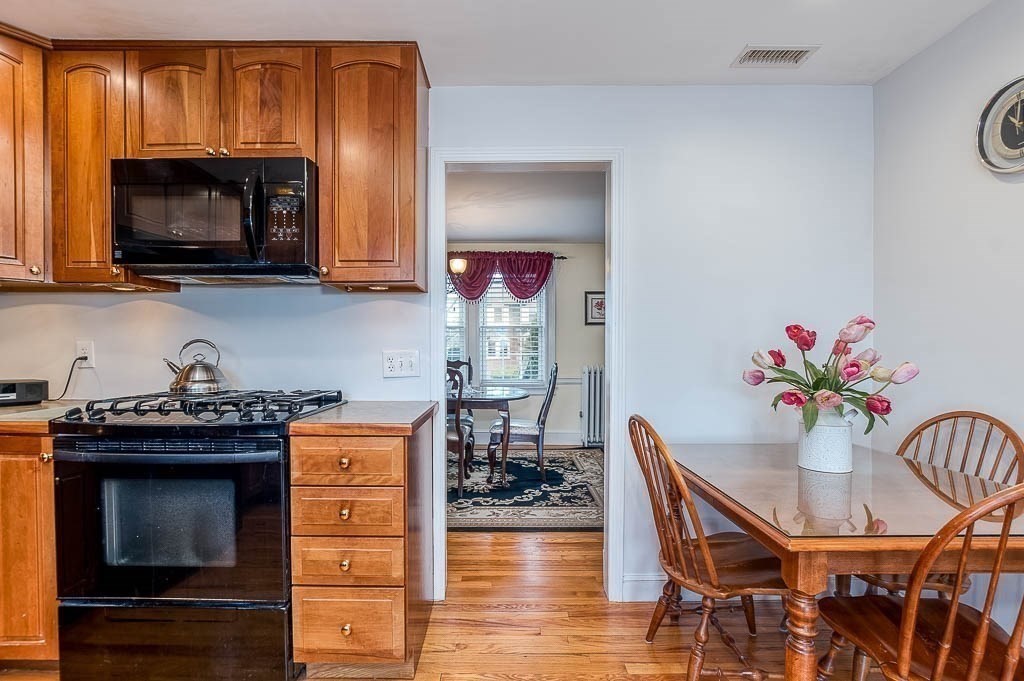 409 Mt Vernon Street Dedham, MA 02026 - Photo 17 of 42 a kitchen with a stove a microwave and wooden floor