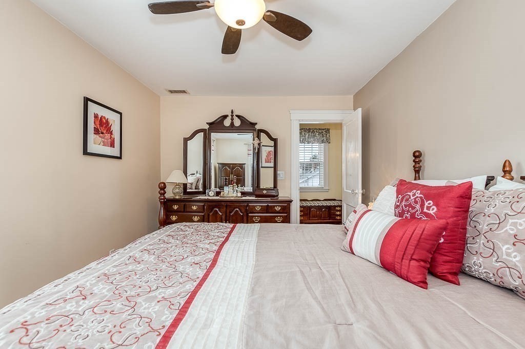 409 Mt Vernon Street Dedham, MA 02026 - Photo 25 of 42 a bedroom with a bed and dresser with mirror