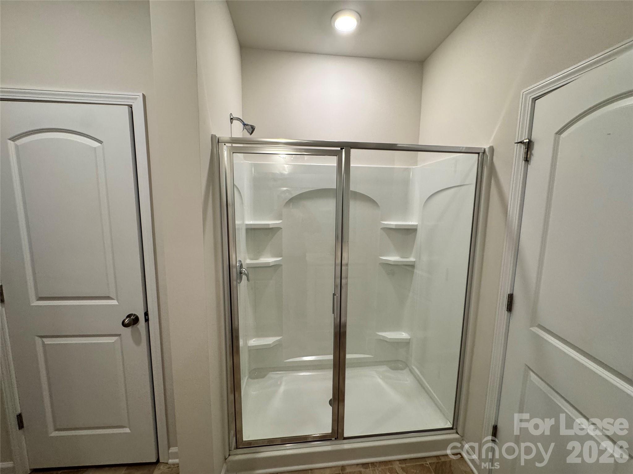 1007 Maylen Trace Monroe, NC 28110 - Photo 13 of 34 a bathroom with a glass shower door and mirror