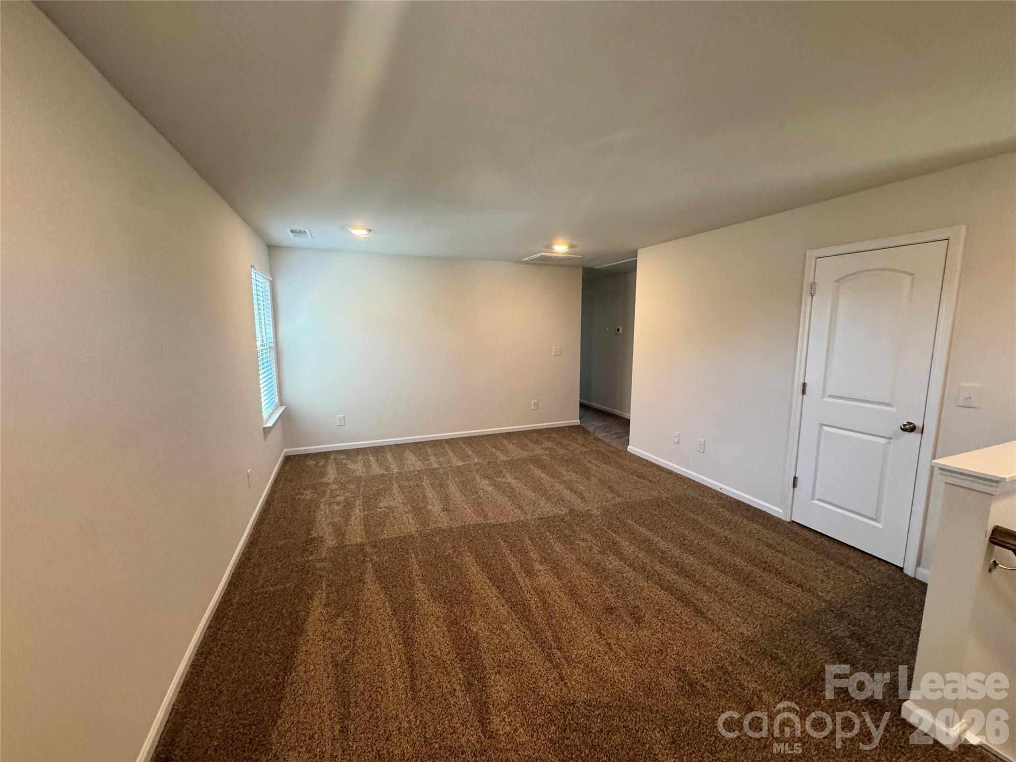 1007 Maylen Trace Monroe, NC 28110 - Photo 19 of 34 an empty room with wooden floor and windows