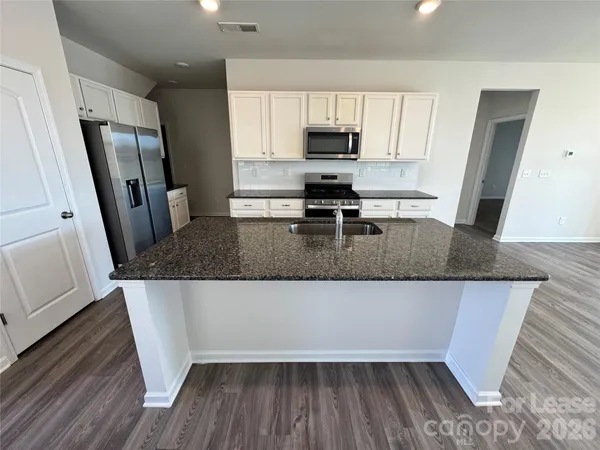 a kitchen with stainless steel appliances granite countertop a stove and a microwave