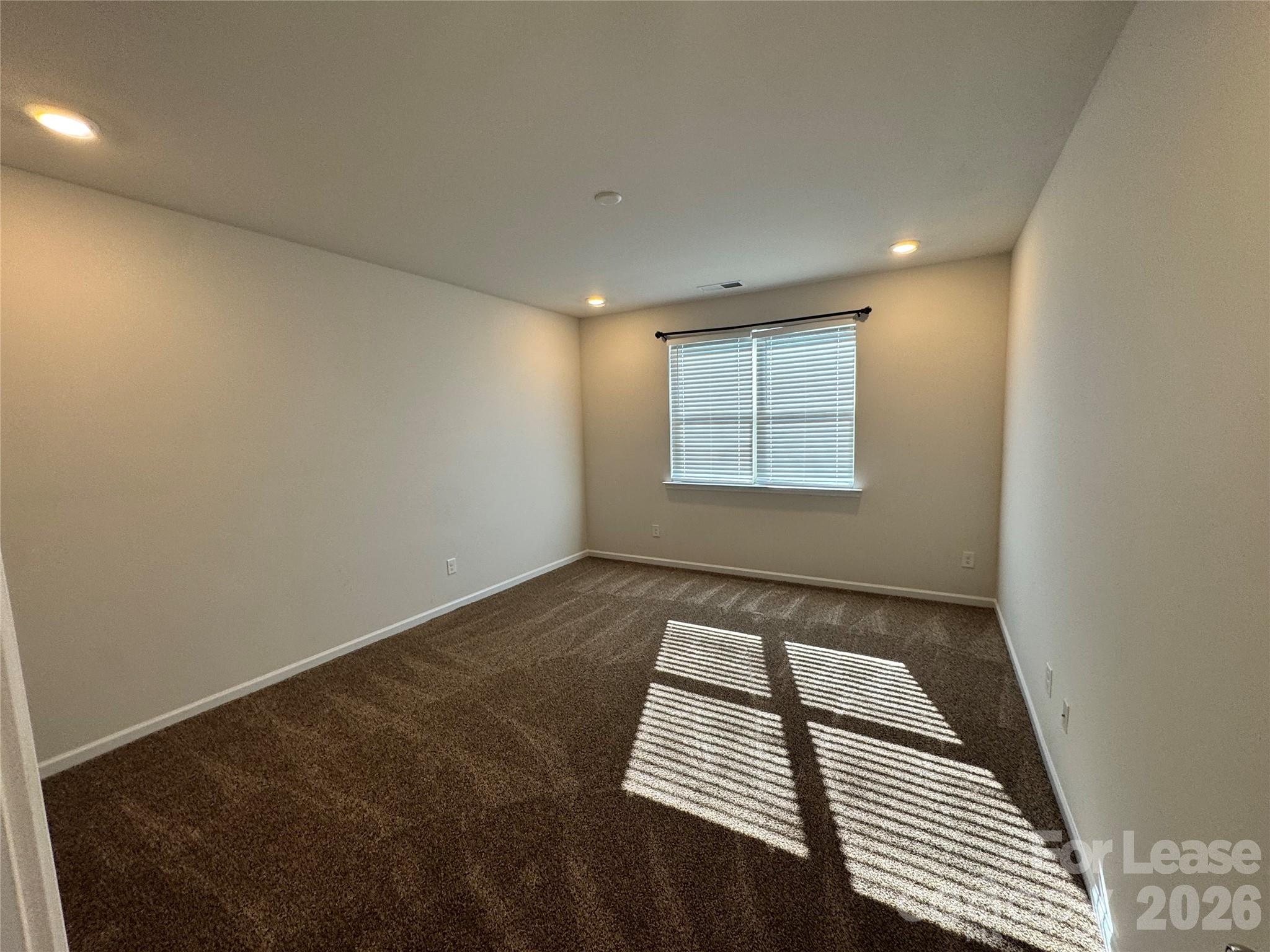 1007 Maylen Trace Monroe, NC 28110 - Photo 10 of 34 an empty room with wooden floor and windows