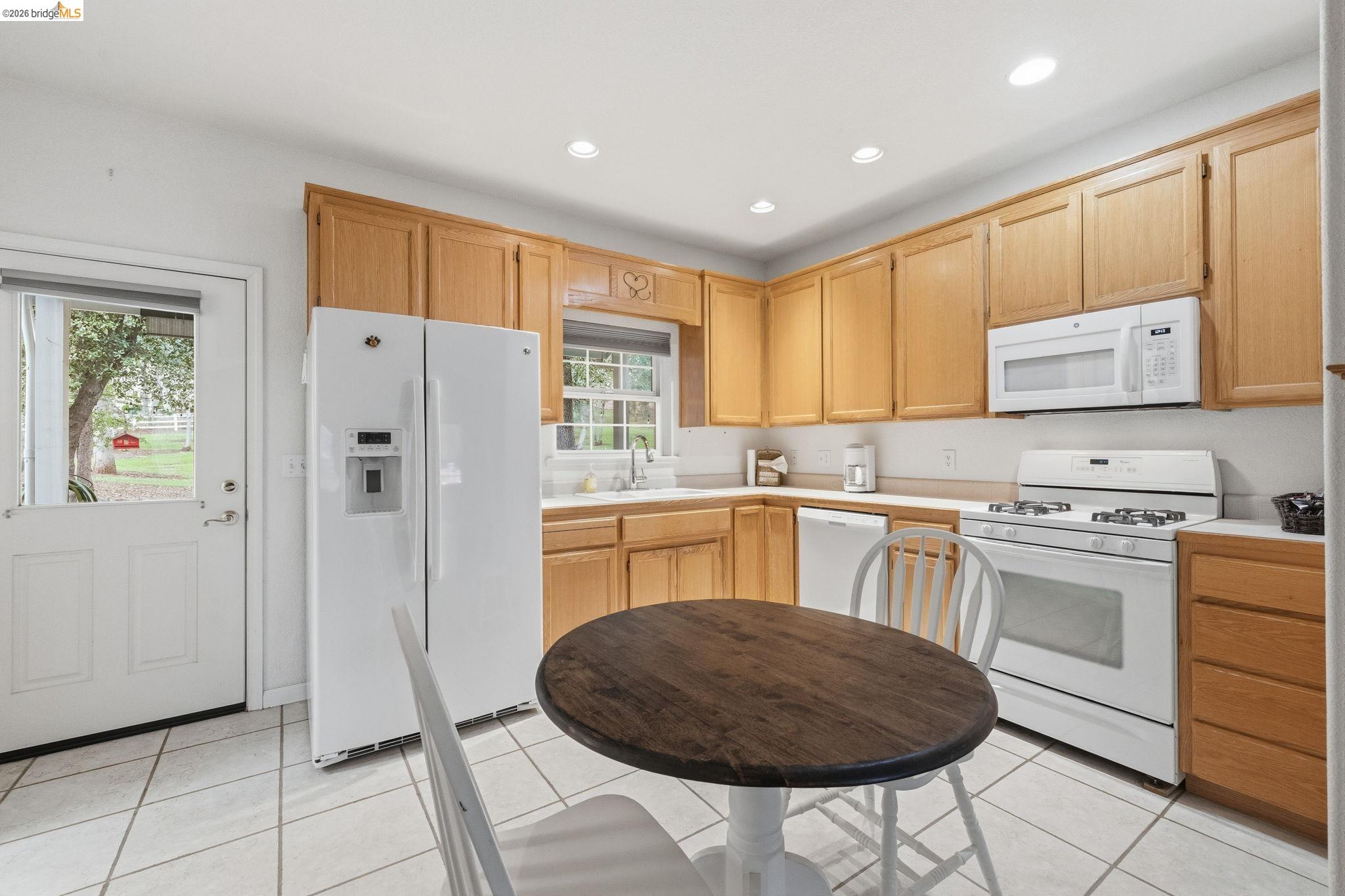 18450 Lambert Lake Road Sonora, CA 95370 - Photo 53 of 87 Kitchen featuring oak cabinetry, white appliances, recessed lighting, and tile flooring