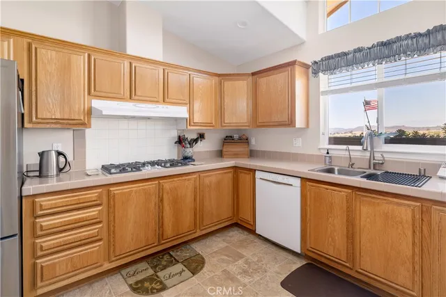 a dining room with kitchen island stainless steel appliances furniture cabinets and a window