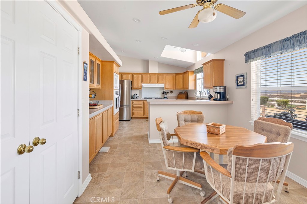 39597 Calle Escalona Temecula, CA 92592 - Photo 21 of 61 a dining room with kitchen island stainless steel appliances furniture cabinets and a window