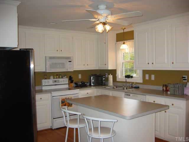 760 Mitchell Road Angier, NC 27501 - Photo 3 of 12 a kitchen with a sink a stove a refrigerator and cabinets