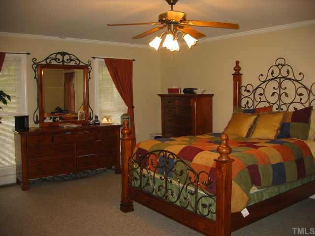 760 Mitchell Road Angier, NC 27501 - Photo 6 of 12 a bedroom with a bed and a chandelier